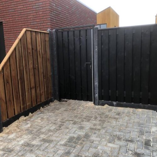 Zwarte tuinpoort met zwarte details tussen premium antraciet betonpalen